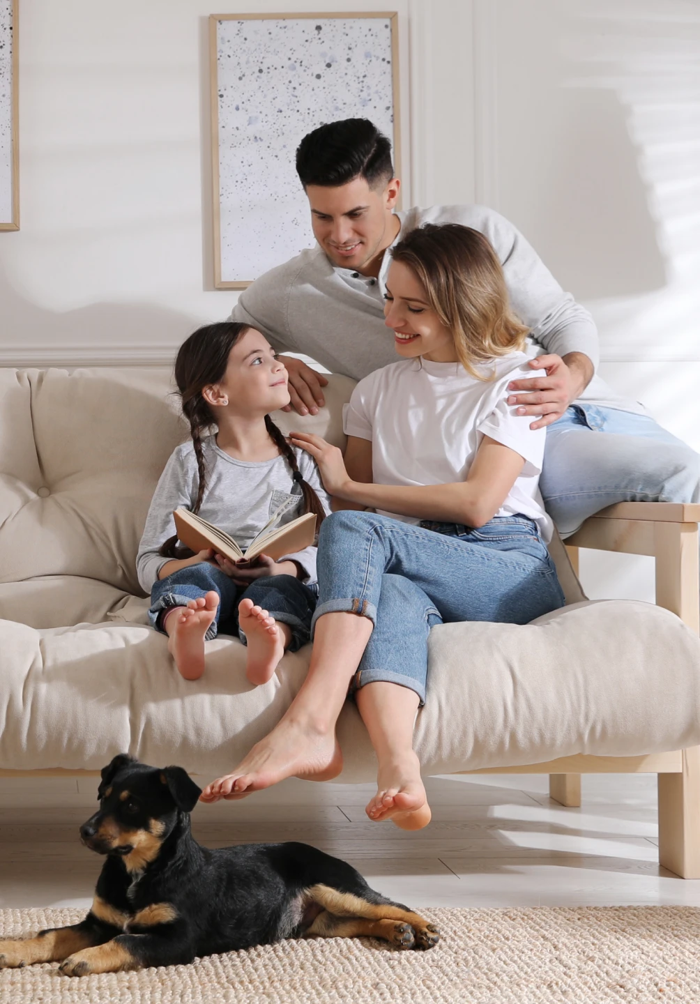 Família sentada num sofá com um cão aos seus pés