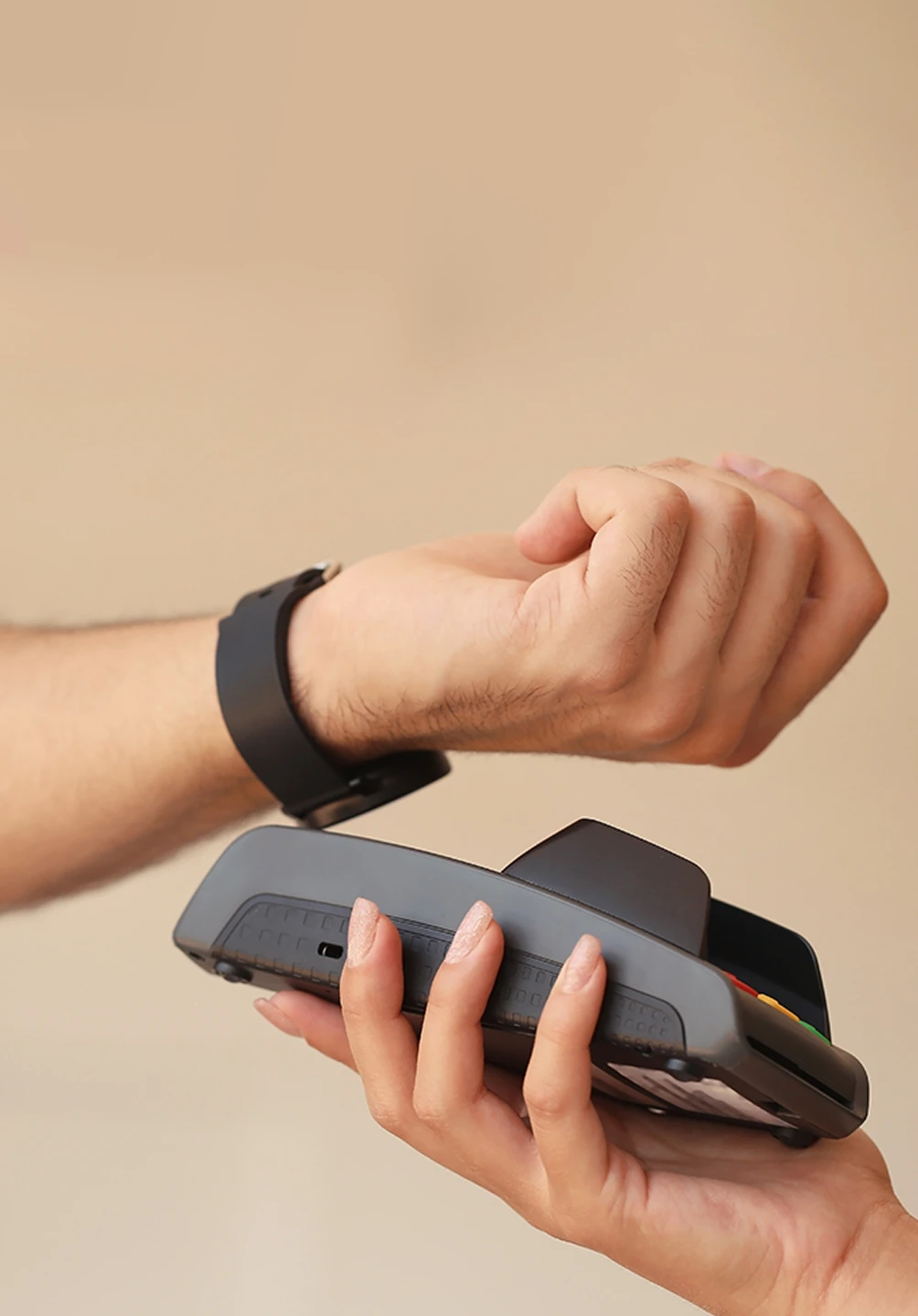 hand with a watch, approaching a payment terminal