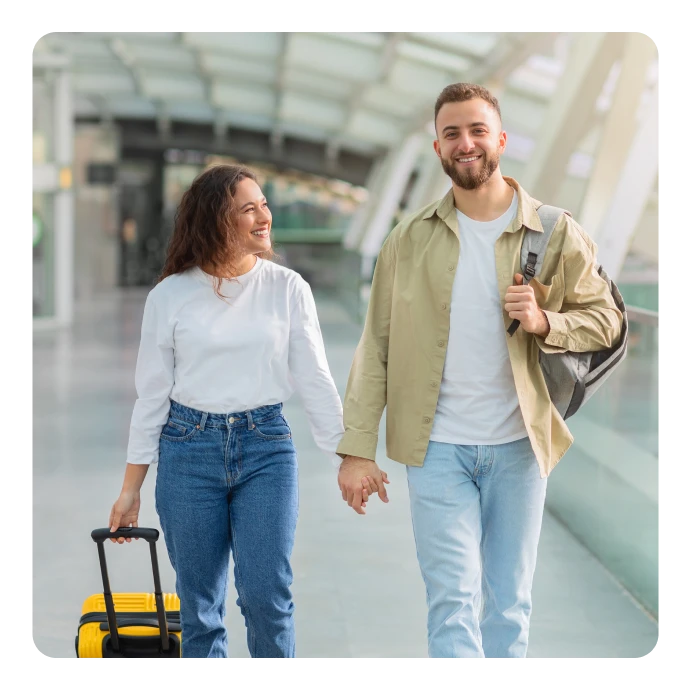 Casal de mãos dadas a caminhar num aeroporto