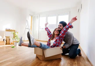 Casal jovem divertido na casa nova, com caixa de mudanças