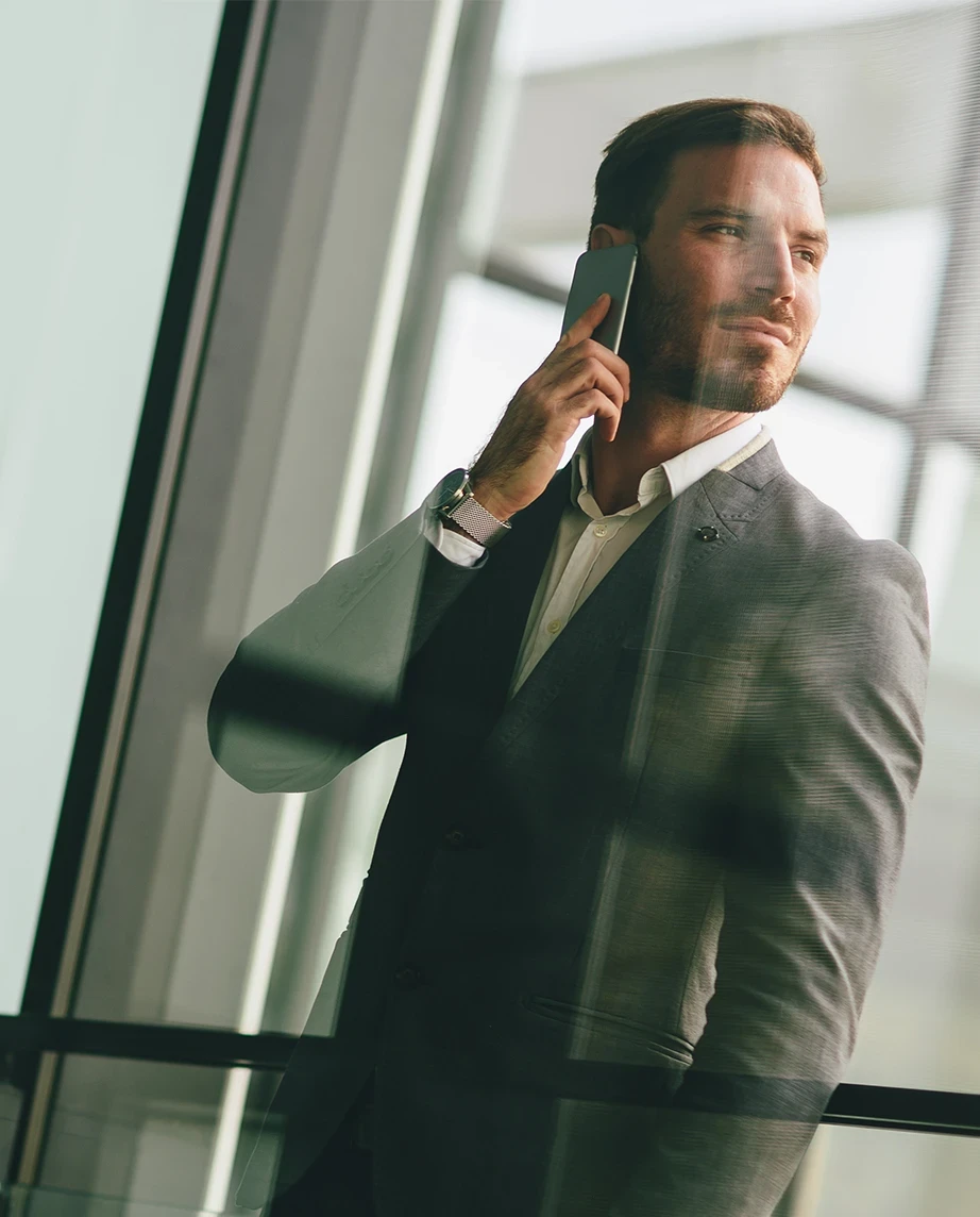 man in a suit and tie, talking on the phone, looking to the side