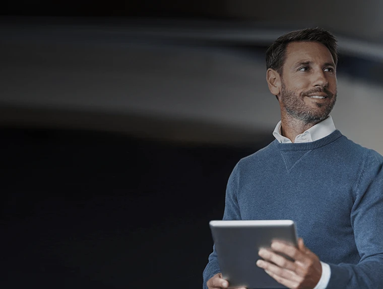 homem com camisola azul e tablet na mão