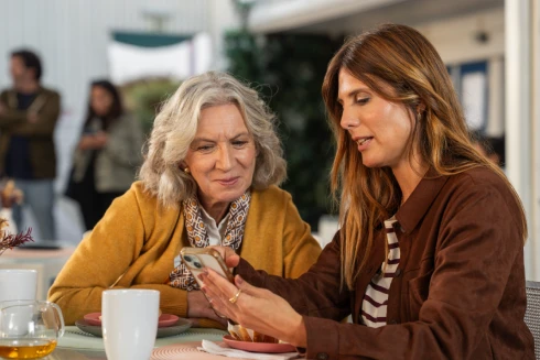 Custódia Gallego, a representar a personagem Fernanda Guimarães, e outra atriz a representar a sua sobrinha, num bar de praia