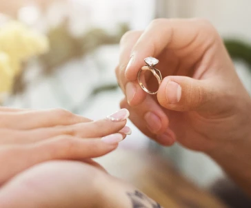 male hand putting a ring on a female hand's finger