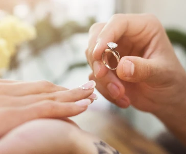 mão masculina a colocar anel no dedo de mão feminina