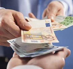 pormenor de mão de um homem a pagar em notas a outra pessoa