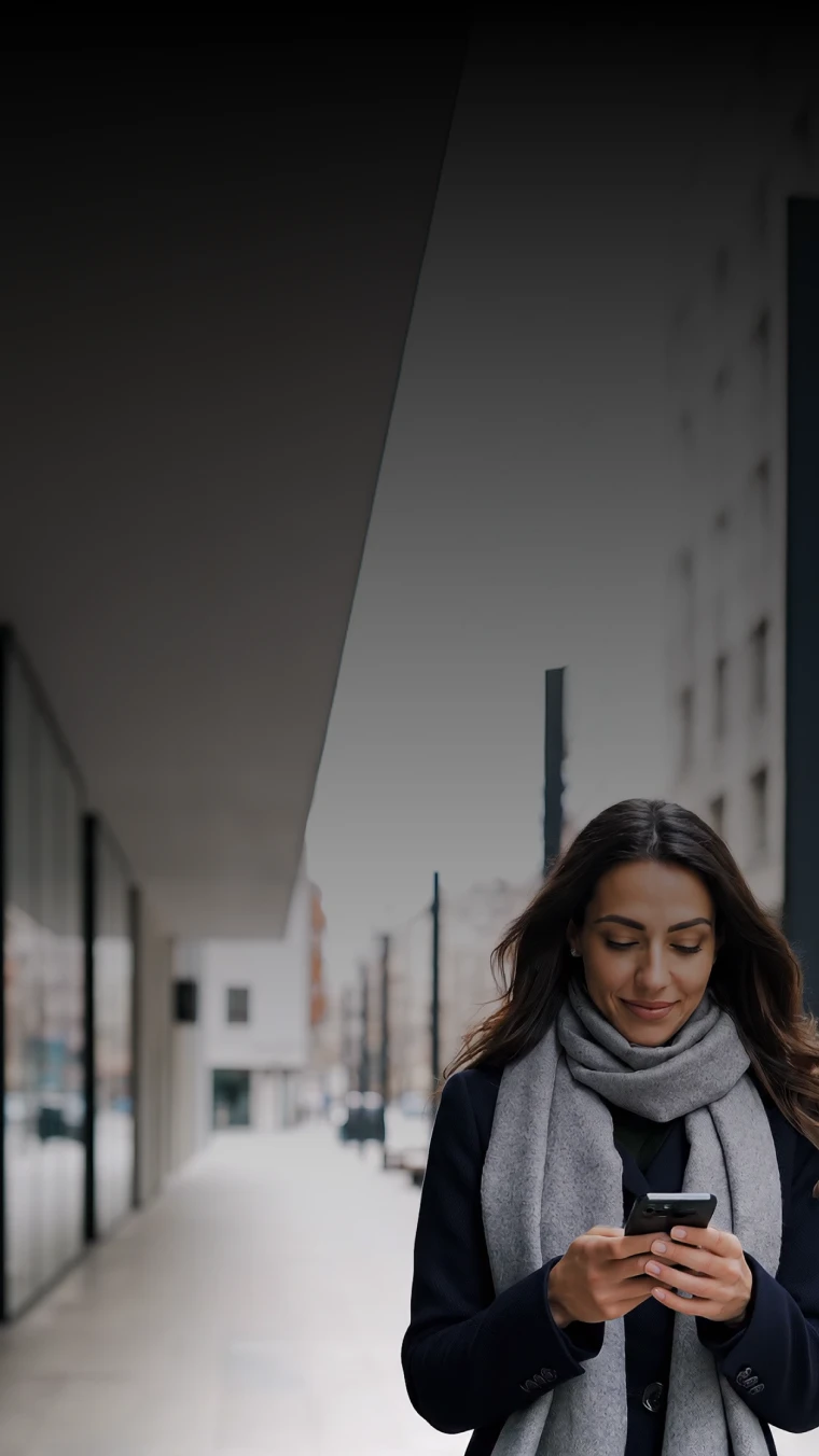 Mulher na rua a usar smartphone, com cachecol e casaco