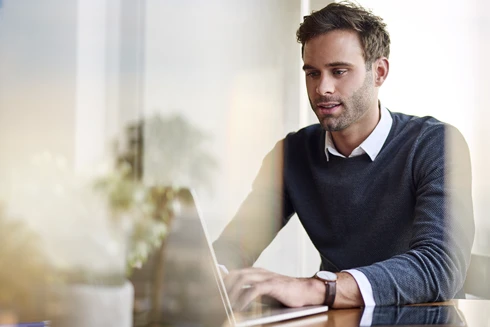 Man sitting in an office, working on a computer