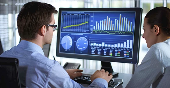 homem e mulher em frente  ecrân de computador com gráficos