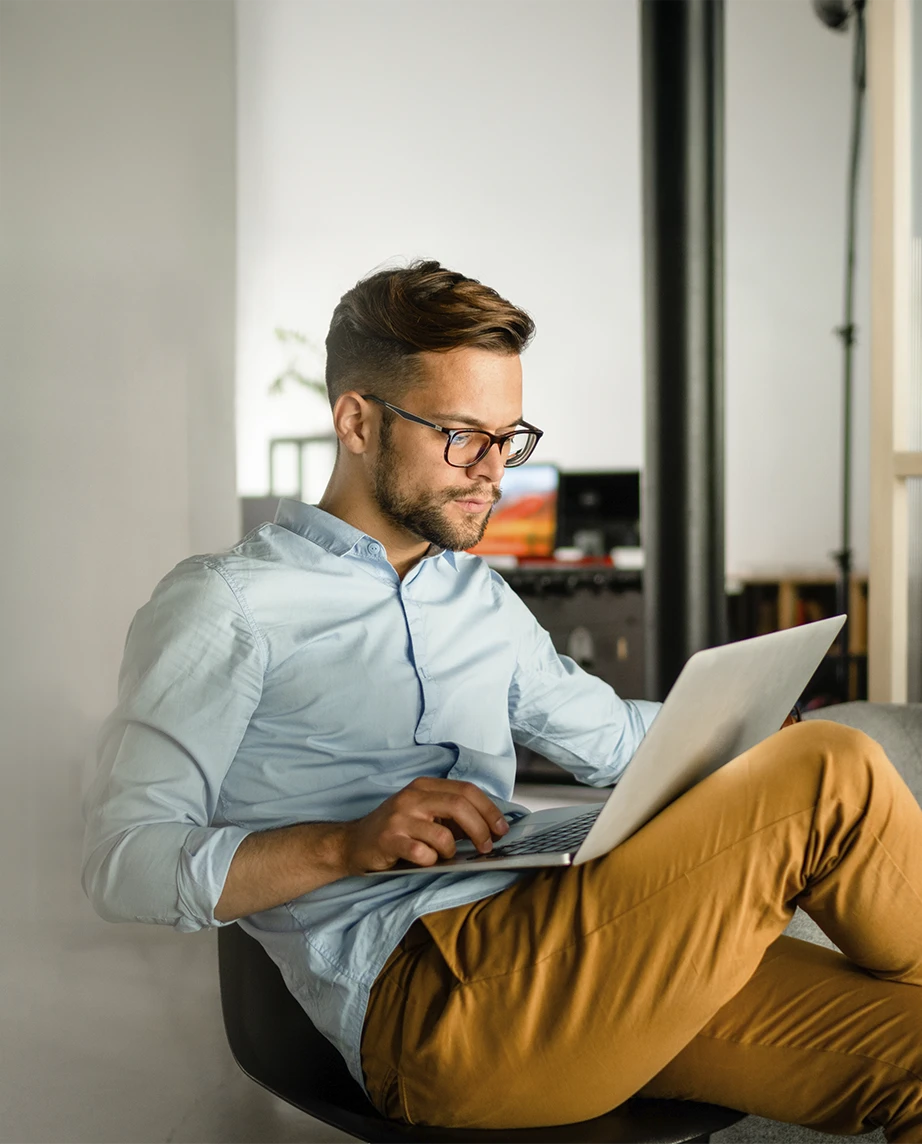 homem sentado num sofá, com computador