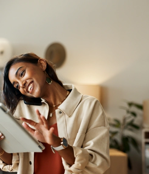 woman talking on the phone and holding a tablet in her hand, in an office