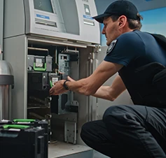 2 seguranças, um a recolher cassete de notas de uma caixa multibanco, e outro de vigia