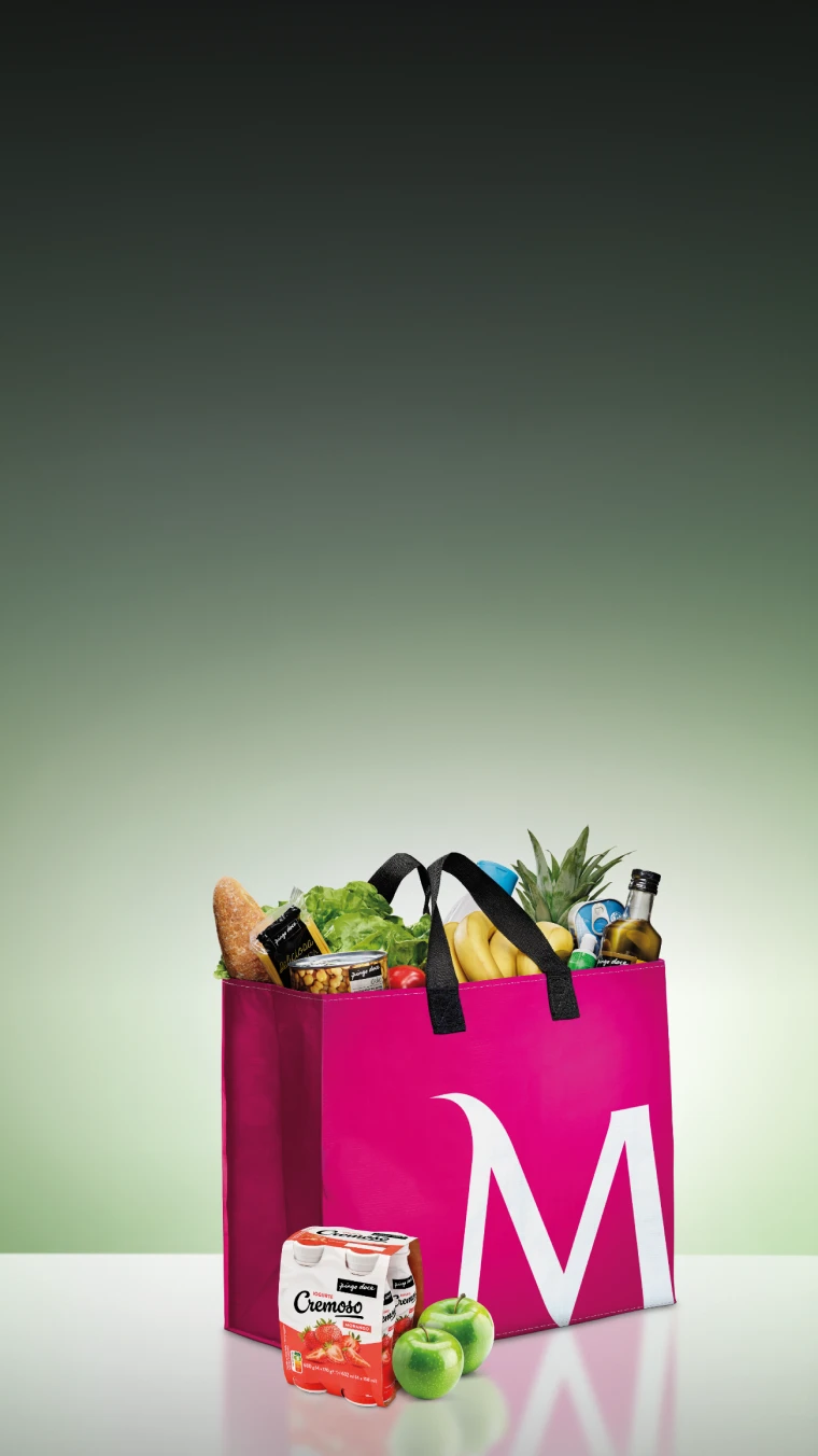 Saco de compras cerise, com o "M" de Millennium bcp desenhado, cheio de fruta, legumes e outra comida