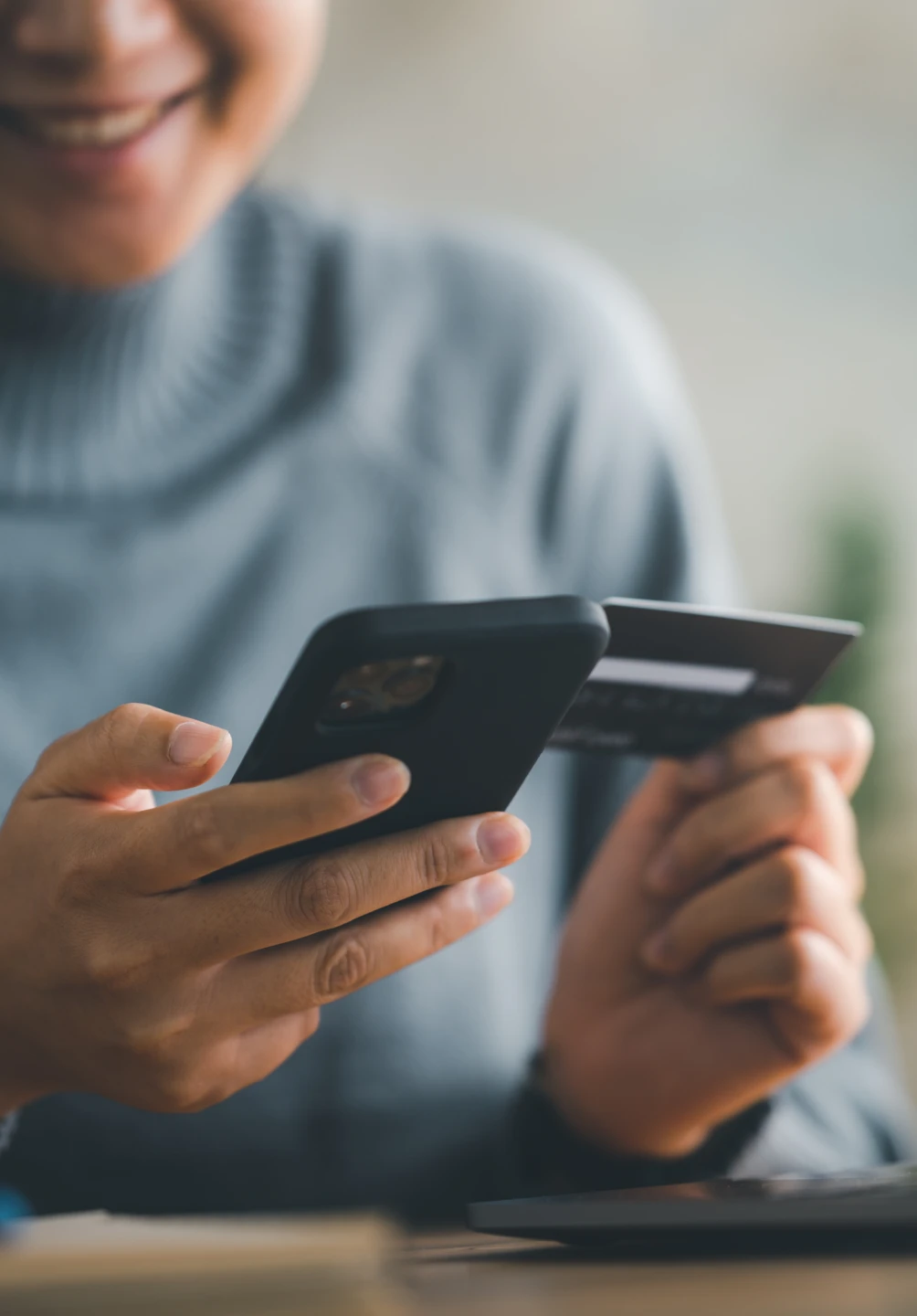Rapariga a pagar num telemóvel com cartão de crédito