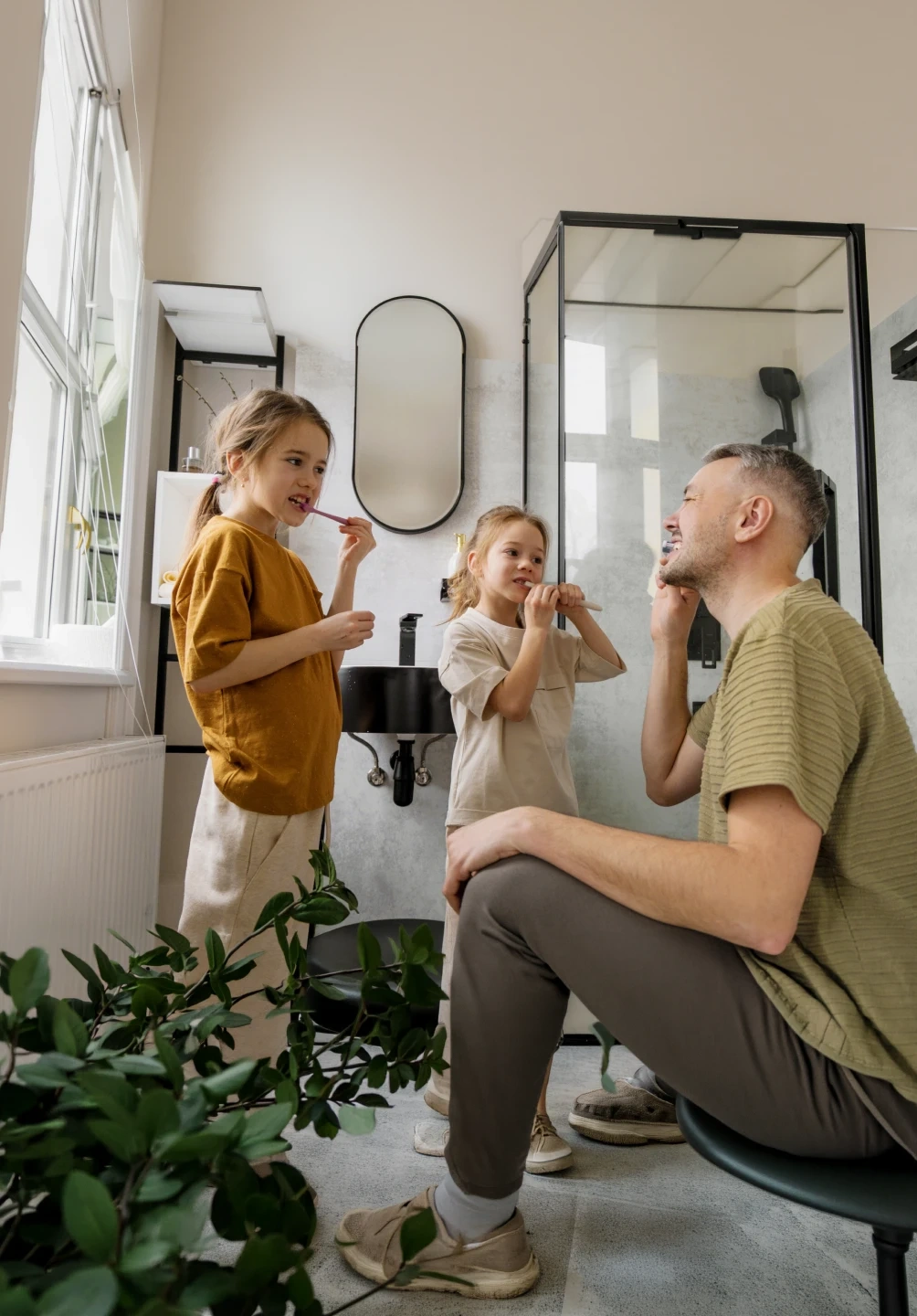 Pai com filhos a escovar os dentes