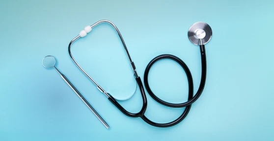 Estetoscópio e martelo de reflexos sobre fundo azul claro