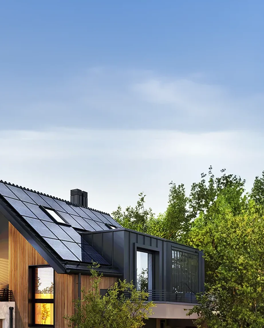 house with solar panels, surrounded by trees