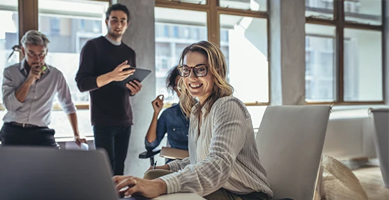 4 pessoas sorridentes, numa sala de reuniões