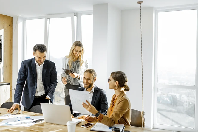 4 people in a meeting in a sunny office