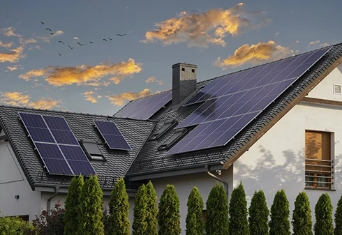 Painéis solares instalados no telhado de uma moradia ao pôr do sol