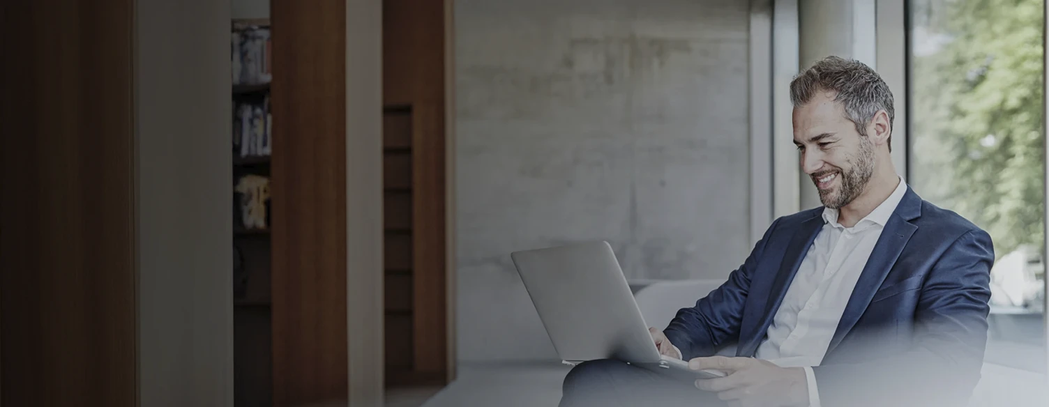 homem sentado na sua sala, com computador ao colo