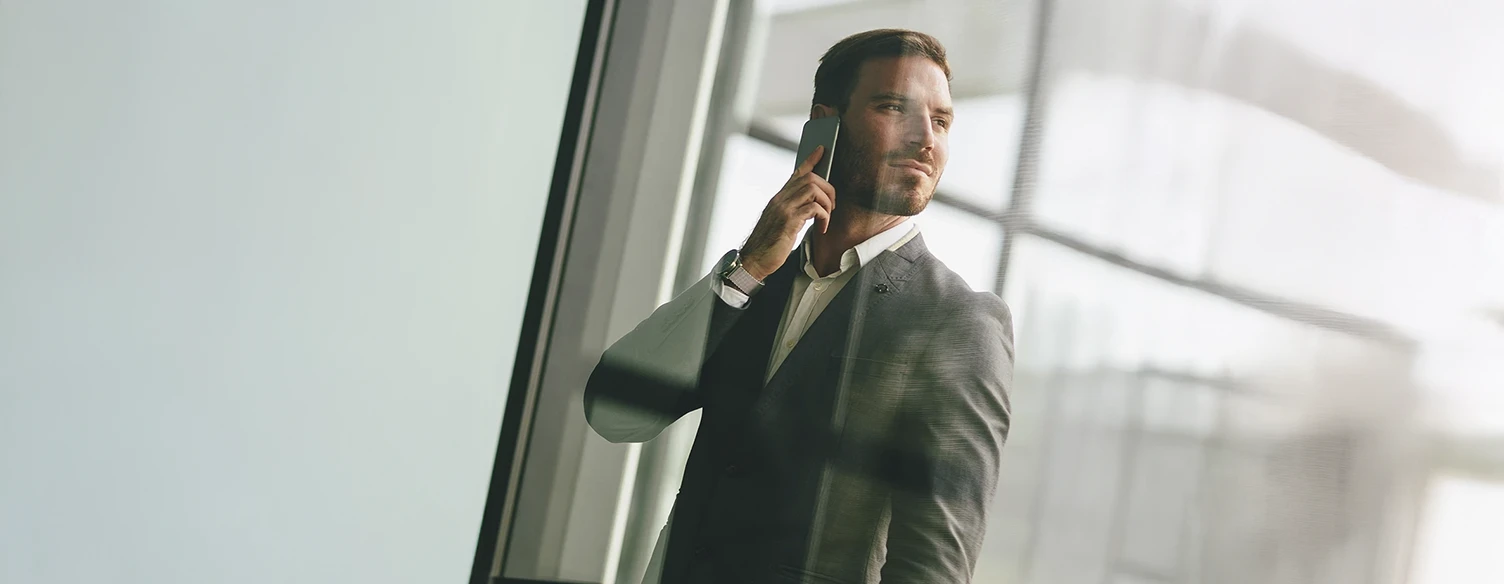 homem de fato e gravata, a falar ao telemóvel, olhando para o lado