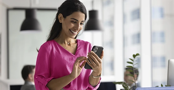 senhora sorridente com telemóvel na mão