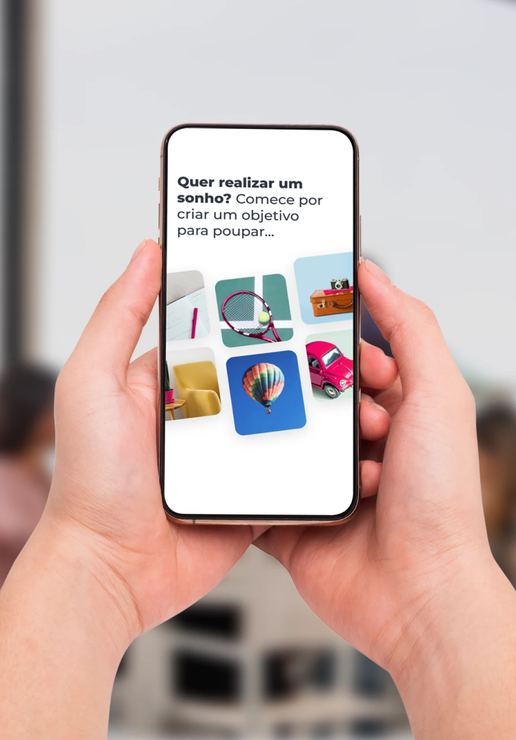 Mãos seguram smartphone com App Millennium que sugere criar objetivos de poupança para realizar sonhos