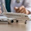 Médico a preencher formulário com um avião de brincar em primeiro plano