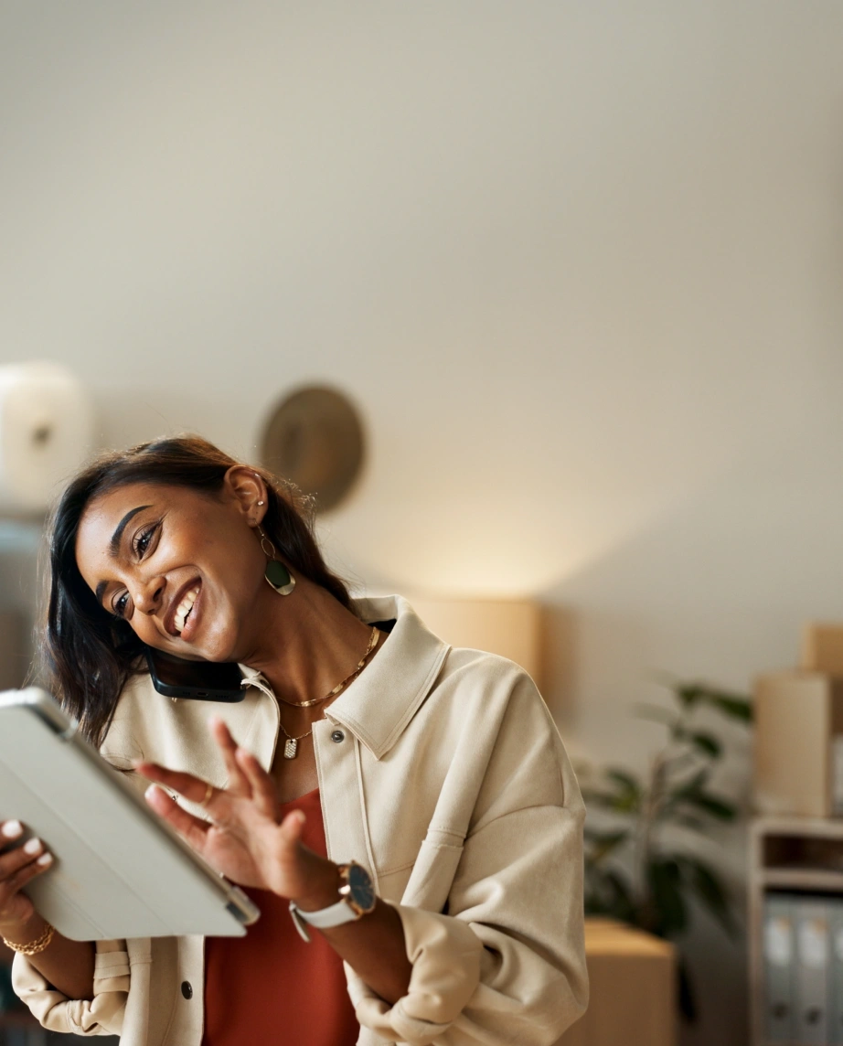 woman talking on the phone and holding a tablet in her hand, in an office