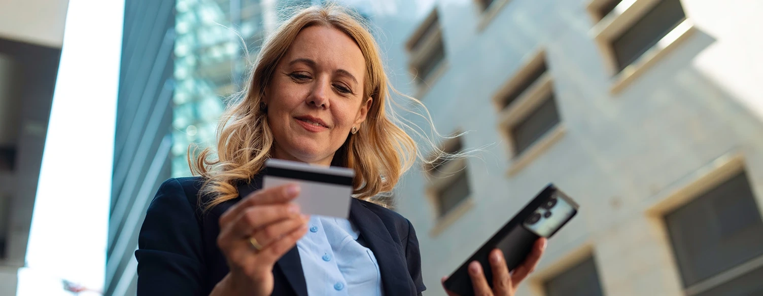 Woman making an online payment with a credit card and mobile phone