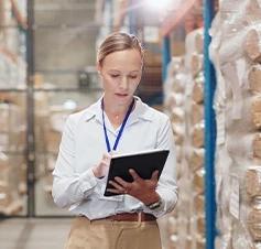 Mulher a verificar o inventário de um armazém num tablet