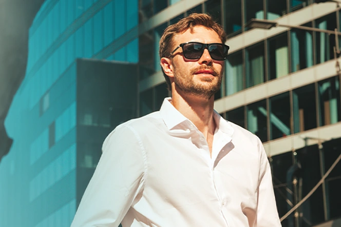 young man wearing sunglasses walking on the street