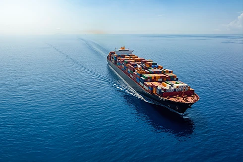 Navio porta-contentores a navegar em alto mar com céu limpo