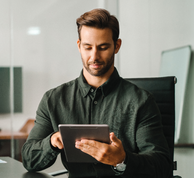 Homem a usar um tablet numa secretária de escritório