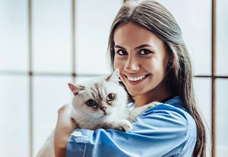veterinária sorridente, com gato ao colo