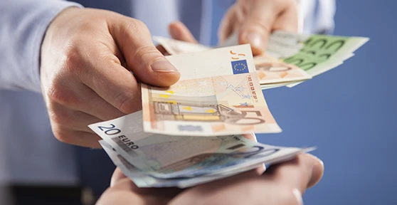 pormenor de mão de um homem a pagar em notas a outra pessoa