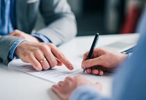 mãos a assinar um contrato