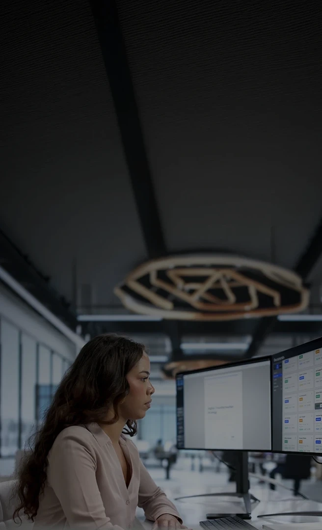 Woman working in front of two monitors in an office