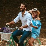 Casal feliz anda de bicicleta no campo