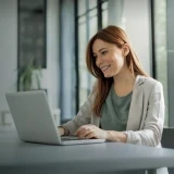 Smiling woman working on a laptop in an office