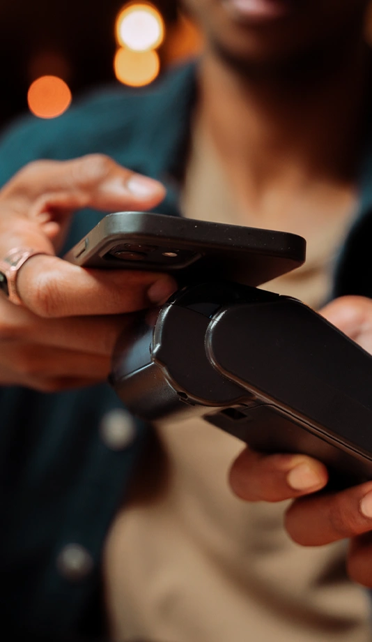 hand tapping a phone on a payment terminal