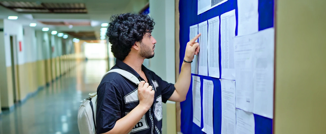 Jovem estudante a consultar pautas num quadro de avisos