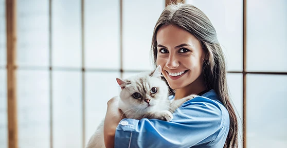 veterinária sorridente, com gato ao colo