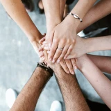 Mãos empilhadas simbolizam união e trabalho em equipa