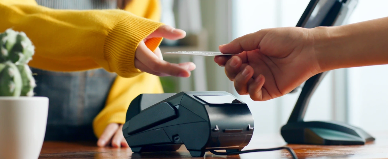 Pessoa a fazer um pagamento com cartão num terminal automático
