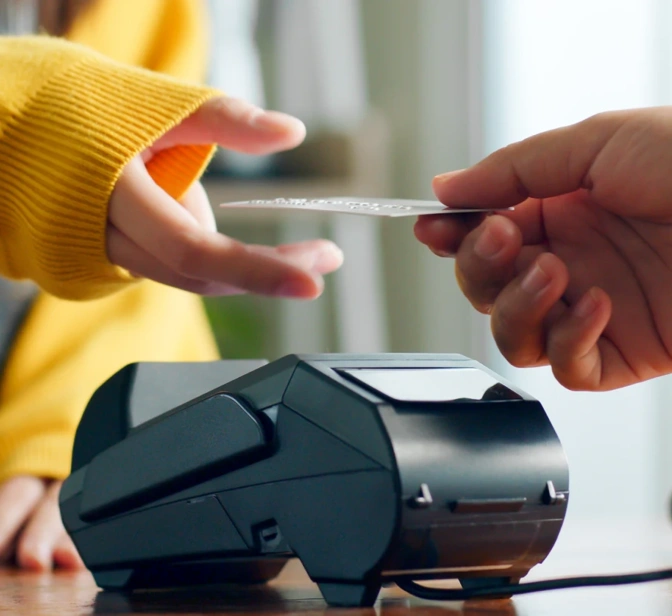 Pessoa a fazer um pagamento com cartão num terminal automático