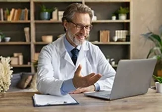 médico em frente a computador, em teleconsulta