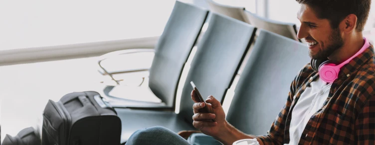 man sitting at airport, making a video call