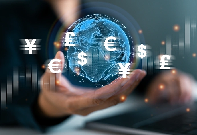 Hand holding a digital globe with various currency symbols around it